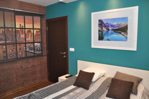 查查克Lux apartman Čačak的一间卧室设有一张床和蓝色的墙壁
