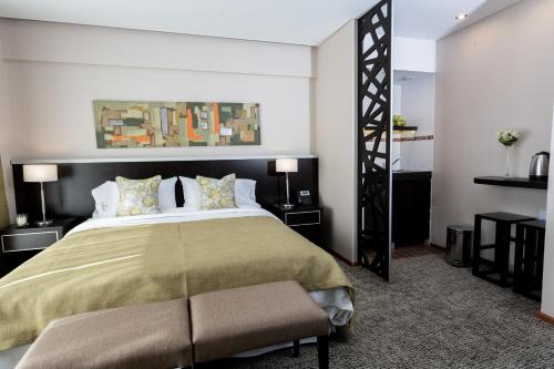 布宜诺斯艾利斯Konke Buenos Aires Hotel的一间卧室配有一张大床和绿色的床罩