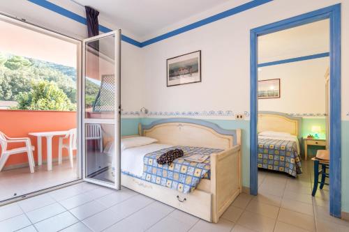 里奥马里纳TH Ortano - Ortano Mare Residence的一间卧室配有一张床,阳台配有桌子