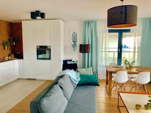 济夫努夫Apartament Gardenia DeLux的客厅配有蓝色的沙发和桌子