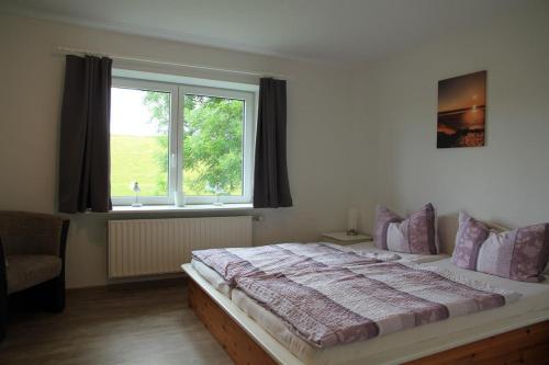 VollerwiekHaus am Meer的一间卧室设有一张大床和一个窗户。