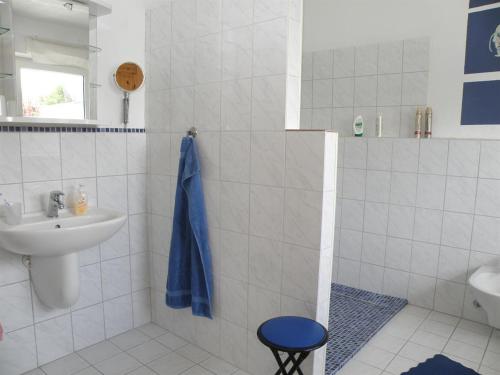 塔廷格Sonnenoase的白色的浴室设有水槽和蓝色毛巾