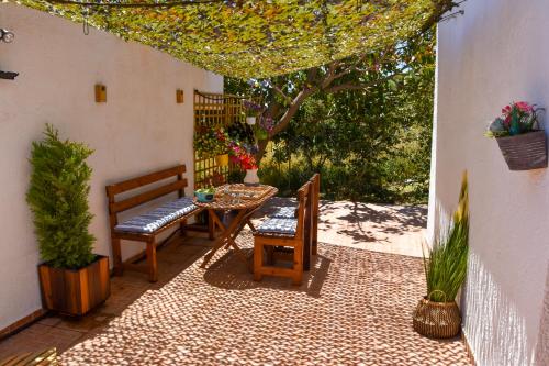 特里欧皮特拉Afrodites Residence Triopetra的庭院设有两把椅子和一张桌子,还有一棵树