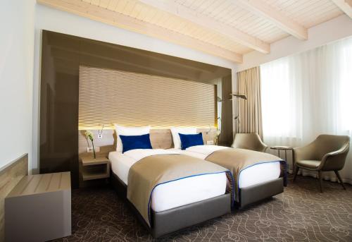 莱比锡Hotel Atlas Leipzig的酒店客房配有两张床和一张书桌