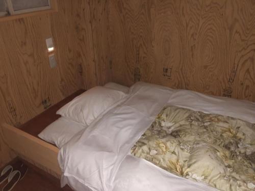 小樽Guesthouse Otaru Wanokaze single room / Vacation STAY 32196的一张带白色床单和枕头的未铺好的床