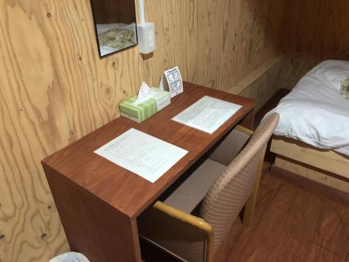 小樽Guesthouse Otaru Wanokaze single room / Vacation STAY 32196的一张桌子,一张桌子和一部电话