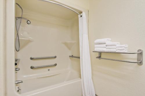 桑蒂Baymont by Wyndham Santee的带淋浴的浴室,配有架子上的毛巾
