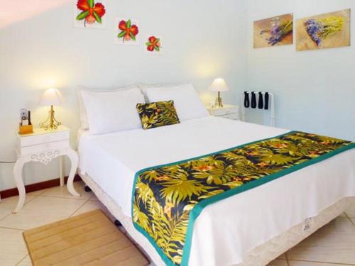 阿布拉奥霍里曾特多斯博尔巴斯酒店的一间卧室配有一张大白色的床和色彩缤纷的毯子