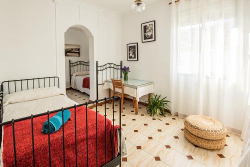 塞维利亚特里亚纳洛斯雷梅迪奥斯公寓的一间卧室配有一张床、一张桌子和一张四柱床。