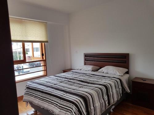 利马Jirón Tarapacá 398, La Punta - Callao的一间卧室配有一张带条纹毯子的大床