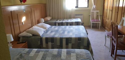 布鲁内特布鲁内特旅舍的带三张床、椅子和窗户的房间