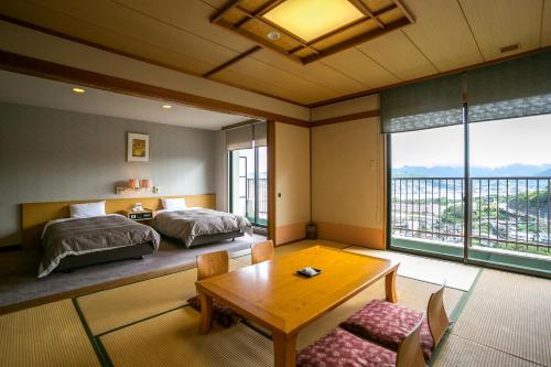 长崎稻佐山观光酒店的一间卧室配有两张床和一张桌子。