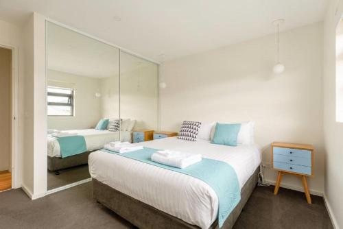 霍巴特袋鼠湾公寓的一间卧室配有两张床和镜子