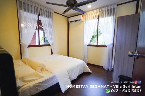 昔加末Homestay Segamat - Villa Seri Intan的一间卧室设有两张床和两个窗户。
