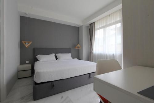 仰光85 SOHO Premium Residences的卧室配有白色的床和窗户。