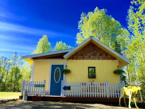 塔尔基特纳Sunshine Cottage的蓝色门的小黄色房子
