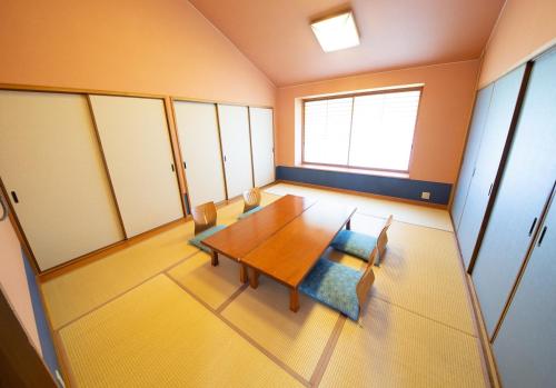 浜田市Kinta no sato的一间带木桌和椅子的用餐室