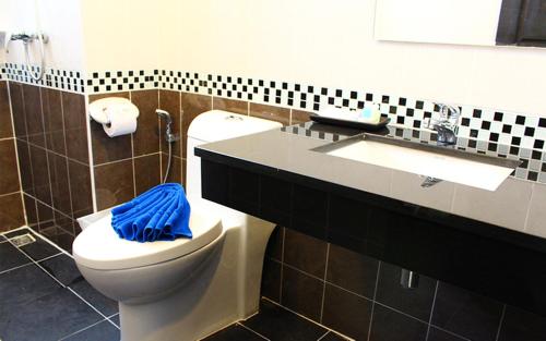 芭东海滩88酒店的浴室设有卫生间和带蓝毛巾的盥洗盆。