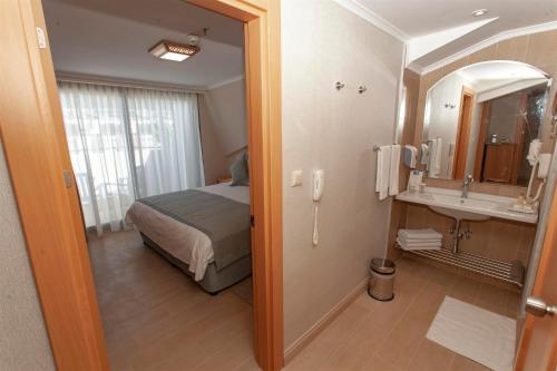 马尔马里斯水上酒店的一间卧室配有一张床,浴室设有水槽
