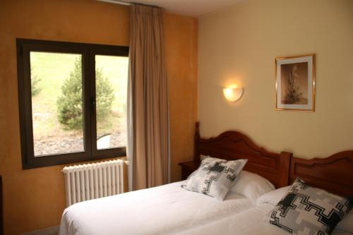 奥尔迪诺苏凯莱酒店的一间卧室设有两张床和窗户。