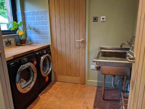 GweekHelford Cottage的厨房配有洗衣机和水槽
