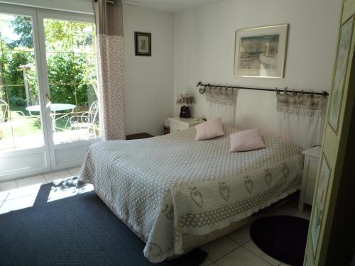 博讷Le Verger du Sausset的一间卧室配有带粉红色枕头的床。