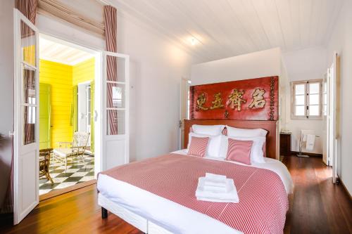 圣丹尼斯Villa Marie Lucie的一间卧室配有一张大床,铺有红白毯子