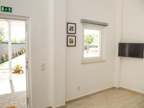 新皮尼亚尔Casa das Pipas #4的一间白色的房间,窗户和墙上的电视