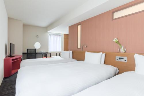 神户the b kobe的一间酒店客房,设有两张床和电视