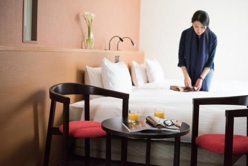 神户the b kobe的站在酒店房间床上的女人