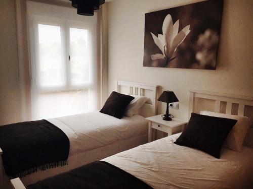 科鲁韦多Apartamento Mirador de Corrubedo的卧室设有两张床,带窗户