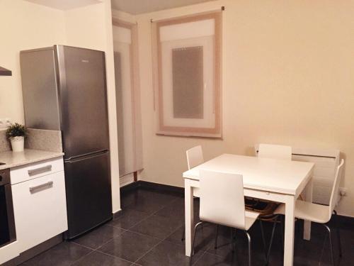 科鲁韦多Apartamento Mirador de Corrubedo的厨房配有白色的桌子和冰箱。