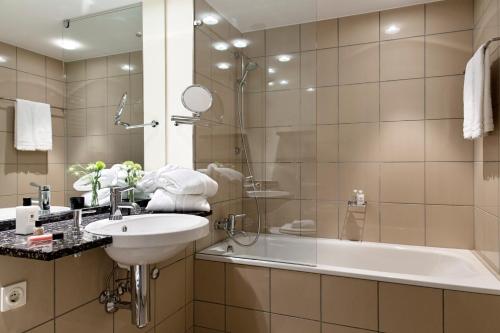 瓦伦克莱斯米尔酒店的浴室配有水槽、淋浴和浴缸。
