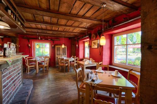 米德尔哈根Hotel & Gasthof Zur Linde的餐厅设有木桌和椅子,拥有红色的墙壁