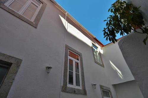 卡斯卡伊斯Casa Joana B&B的白色的建筑,旁边设有窗户