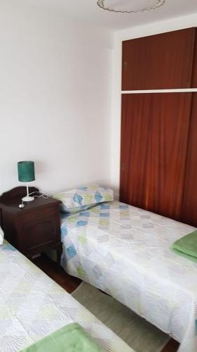 洛马斯-德萨莫拉Departamento Céntrico En Lomas de Zamora的一间卧室配有两张床和一张带台灯的桌子