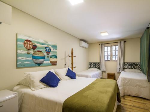 坎波斯杜若尔当Villa Vintage Campos - Piscina e opções de suites com hidromassagem的一间卧室配有两张床,并画有热气球