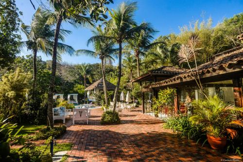 布希奥斯Barracuda Eco Resort Búzios的棕榈树和砖砌走道的度假村
