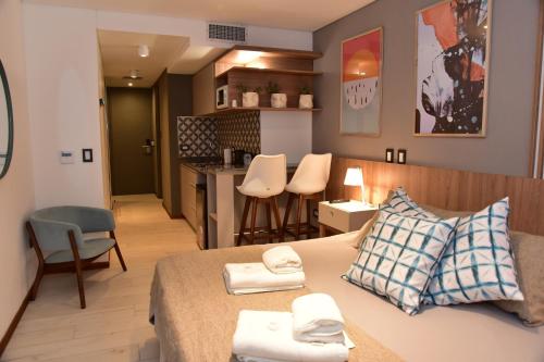 马科斯化雷斯Nuevo Centro Apart Hotel & Suites的小房间设有床和厨房