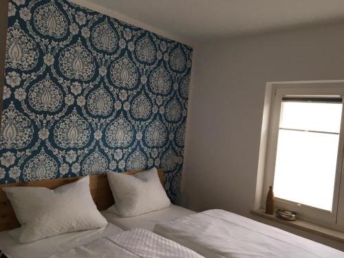 吕本瑙Kirchturmblick的一间卧室配有一张蓝色和白色壁纸的床