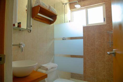 圣安德烈斯-图斯特拉放松套房酒店的一间带水槽和卫生间的浴室以及窗户。