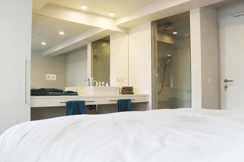 斯塔沃洛Remacle3的一间带白色大床的卧室和一间浴室