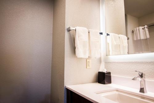 安克雷奇速8安克雷奇酒店的浴室配有盥洗盆、镜子和毛巾