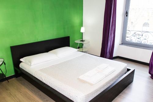 罗马多莫斯奥塔维亚诺幸运公寓的一间卧室设有一张大床和绿色的墙壁
