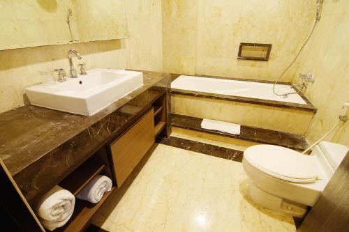 茂物茂物皇家酒店的浴室配有盥洗盆、卫生间和浴缸。