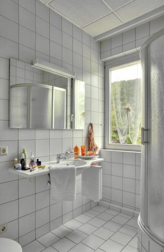 巴特泰纳赫-察费尔施泰因特纳施塔尔酒店的白色瓷砖浴室设有水槽和窗户