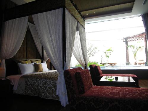 中坜摩斯时尚汽车旅馆的一间卧室配有一张天蓬床、椅子和窗户