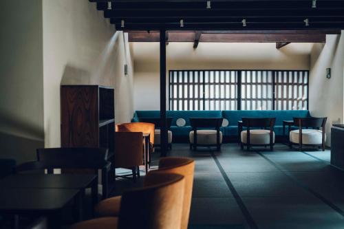 京都Luxury hotel SOWAKA的一间设有椅子和蓝色沙发的等候室