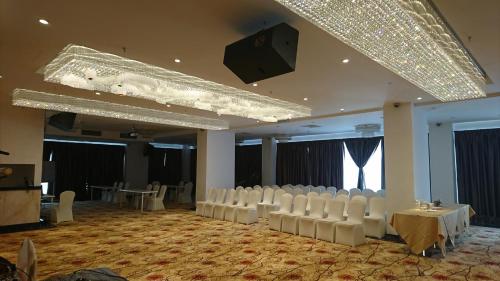 吉隆坡B公园酒店的一间大房间,配有白色椅子和舞台