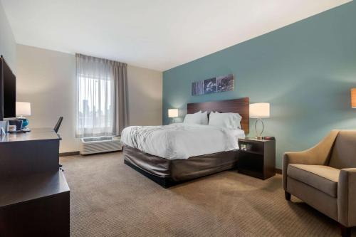 俄克拉何马城Sleep Inn & Suites Bricktown - near Medical Center的配有一张床和一把椅子的酒店客房